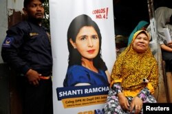 Seorang perempuan duduk di depan poster Shanti Ramchand, caleg dari Partai Nasdem saat kampanye di Jakarta, 14 Maret 2019. (Foto: Willy Kurniawan/Reuters)