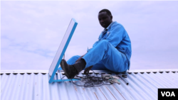 A worker installs a BBOXX solar panel on a rooftop in Kakuma, a refugee camp in northwest Kenya. (M. Yusuf/VOA)