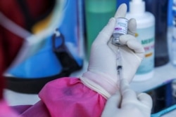 Seorang petugas kesehatan menyiapkan dosis vaksin AstraZeneca COVID-19 selama program vaksinasi massal untuk Wisata Zona Hijau di Sanur, Bali, 23 Maret 2021. (Foto: REUTERS/Nyimas Laula)