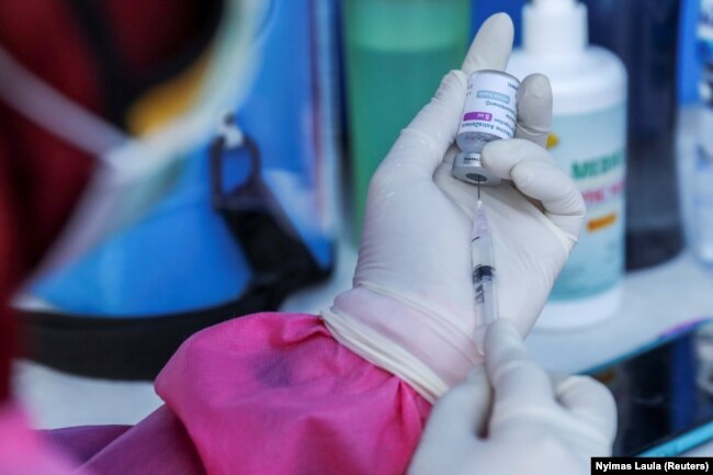 Seorang petugas kesehatan menyiapkan dosis vaksin AstraZeneca COVID-19 selama program vaksinasi massal untuk Wisata Zona Hijau di Sanur, Bali, 23 Maret 2021. (Foto: REUTERS/Nyimas Laula)