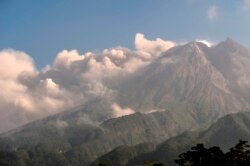 Gunung Merapi menyemburkan abu dan asap setinggi 3.500 meter dari puncaknya terlihat dari Sleman di Yogyakarta, 16 Agustus 2021. (Foto: Agung Supriyanto / AFP)