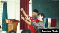 Phan Thị Hoài Yến hướng dẫn học sinh tại một trường trung học ở Việt Nam sử dung bao cao su (Ảnh: AIESEC)