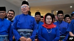 FILE - Former Malaysian Prime Minister Najib Razak, second left in front, and his wife Rosmah Mansor prepare to leave for an election nomination center in Pekan, Pahang state, Malaysia, April 28, 2018. 