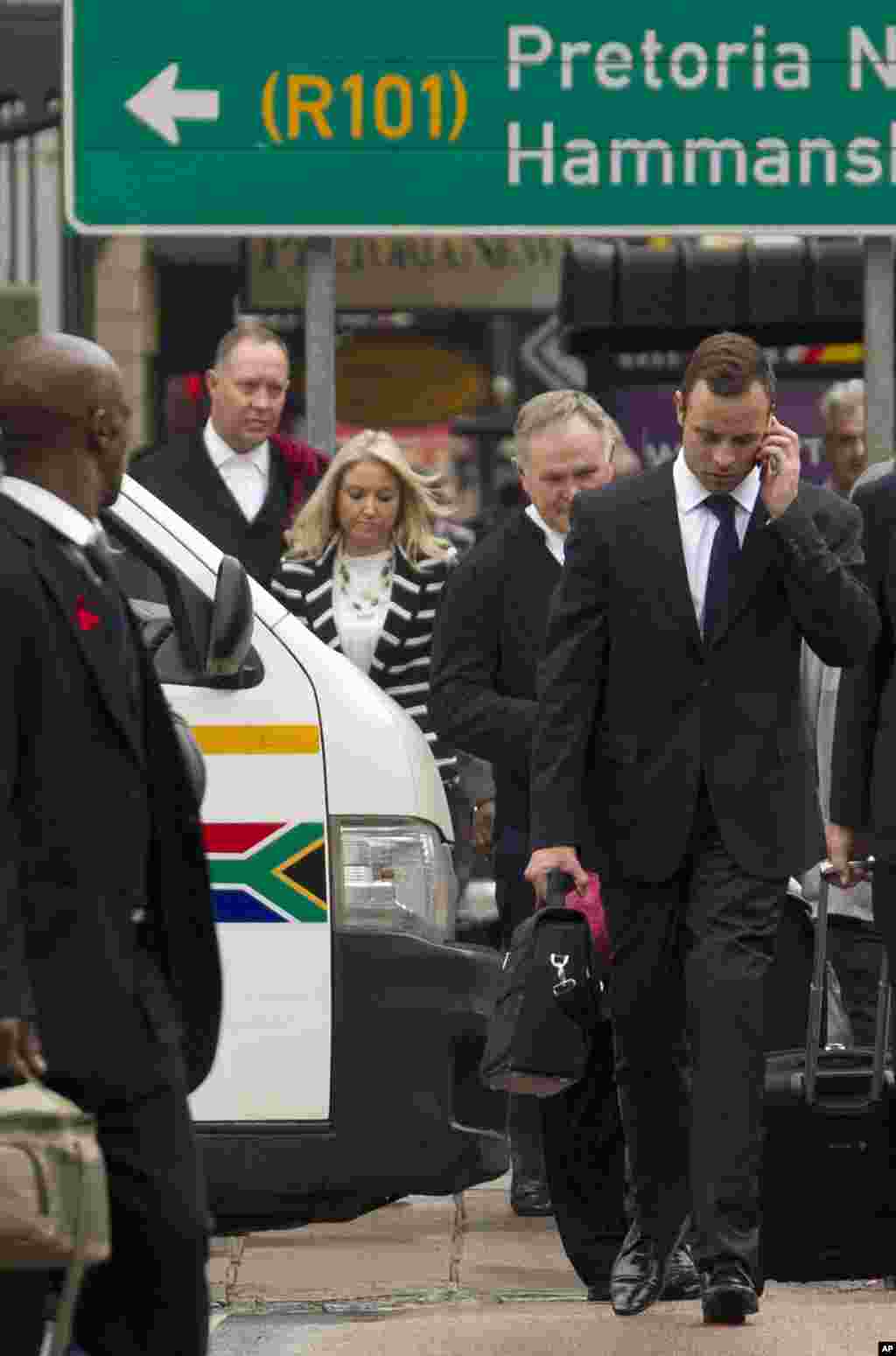 Oscar Pistorius, walks with his legal team towards the high court in Pretoria, March 12, 2014.