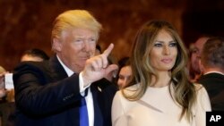 Republican presidential candidate Donald Trump, left, waves as he stands with his wife Melania Trump before speaking at a New York primary night campaign event, Tuesday, April 19, 2016, in New York. (AP Photo/Julie Jacobson)