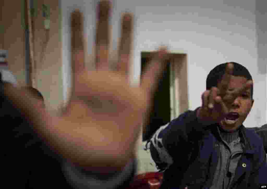 Libyan children gesture as they leave with their family from Libya to Egypt near the border town of Musa'id, Libya, Sunday, March 13, 2011. Moammar Gadhafi's forces swept rebels from one of their final strongholds on Libya's main coastal highway on Sunday