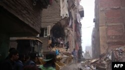 Petugas penyelamat Mesir mencari korban di antara reruntuhan bangunan yang ambruk di Matariya, Kairo utara, Selasa (25/11).