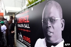 FILE - A banner with a picture of Dakar's mayor Khalifa Sall, in jail awaiting trial for what supporters say are politically motivated embezzlement charges, is on display in front of his offices in Dakar on July 31, 2017, a day after legislative elections