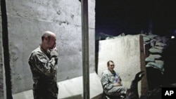 Soldiers from the US Army's 10th Combat Aviation Brigade take a break in a designated smoking area at Jalalabad Air Field in Nangarhar province, Afghanistan, May 3, 2011