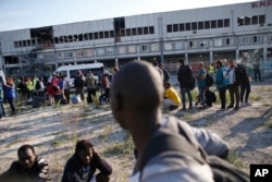 FILE - Migrants line up as they wait to be evacuated from a makeshift street camp, in Paris, France, July 7, 2017.