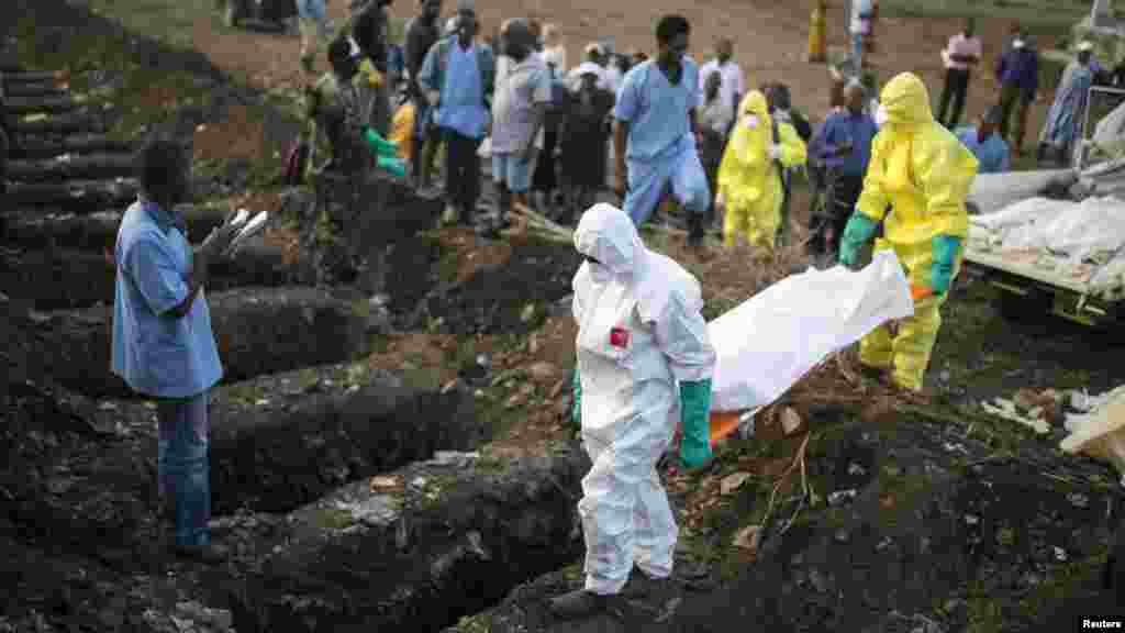 Le personnel de santé emporte le corps d&rsquo;une victime d&rsquo;Ebola qui va être enterré à Freetown, 17 décembre 2014. REUTERS / Baz Ratner