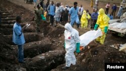 Les agents de santé portent le corps d'une victime Ebola pour l'enterrement dans un cimetière de Freetown, le 17 Décembre 2014.