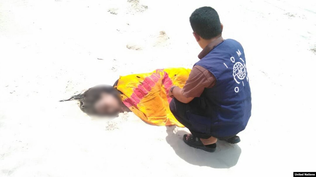 UN Migration Agency staff tend to the remains of a deceased migrant on a beach in Yemen.