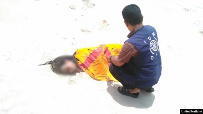 UN Migration Agency staff tend to the remains of a deceased migrant on a beach in Yemen.