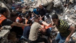Palestinci u ruševinama stambene zgrade koju je bombardovala vojska Izraela 16. maja 2021. u Gazi.