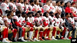 Members of the San Francisco 49ers kneel during the national anthem as others stand during the first half of an NFL football game against the Arizona Cardinals, Oct. 1, 2017, in Glendale, Arizona.