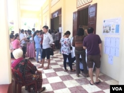 Voters look for names and line up to vote at a polling station at Wat Niroth temple in Niroth commune of Phnom Penh's Chbar Ampov district. (Hul Reaksmey/VOA Khmer)