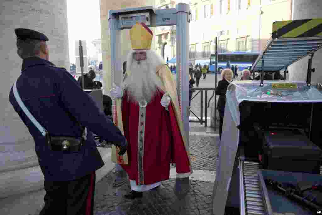 Germany&#39;s Wolfgang Kimmig-Liebe, who has been volunteering as Santa Claus for years, passes through a metal detector before entering in St. Peter&#39;s Square at the Vatican to attend Pope Francis general audience.