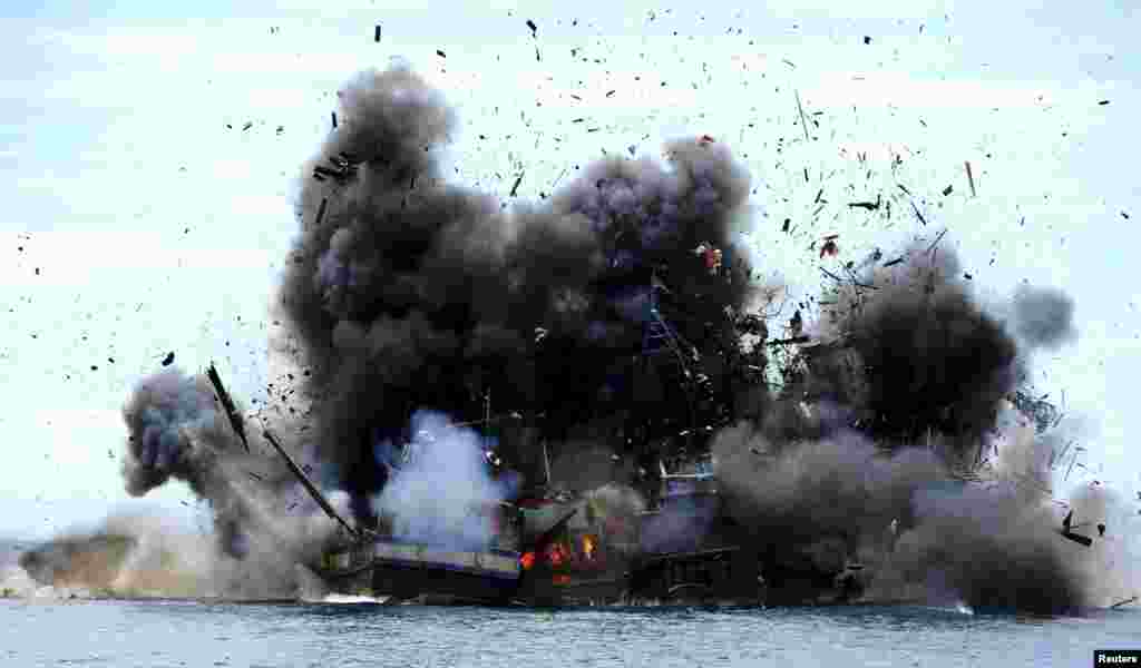 Four of eight confiscated Vietnamese fishing boats are destroyed in Mempawah Regency, West Kalimantan, Indonesia in this photo taken by Antara Foto. The Ministry of Maritime Affairs and Fisheries, together with the Indonesian Navy, destroyed 30 foreign fishing vessels in different locations across the country, which were seized earlier for illegal fishing in Indonesian waters.