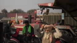 Sonu Singh ties his turban while getting ready to join other farmers protesting against new farming laws they say will result in exploitation by corporations.