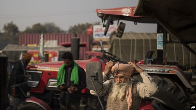 Sonu Singh ties his turban while getting ready to join other farmers protesting against new farming laws they say will result in exploitation by corporations.