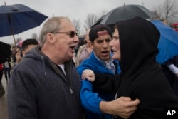 FILE - A Donald Trump supporter, left, and a protester argue before the candidate's arrival in West Chester, Ohio, March 13, 2016. Democratic and Republican views of the opposing political party have sunk to such lows that many say their rivals make them feel afraid, according to a Pew Research Center poll released June 22, 2016.
