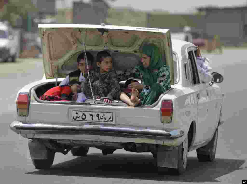 An Afghan family travels in the trunk of a car on the outskirts of Kabul, Afghanistan. 