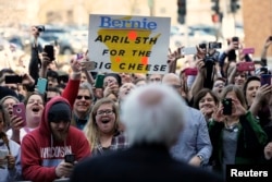 Supporters of U.S. Democratic presidential candidate Bernie Sanders cheer as he speaks to the overflow crowd at a town hall event in Appleton, Wisconsin, March 29, 2016.