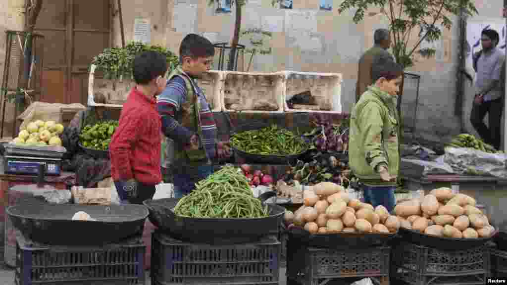 Boys pass by a vegetable stall in Aleppo, Oct. 21, 2013. 