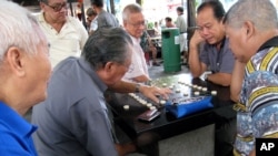 Elderly men play board games in Singapore.