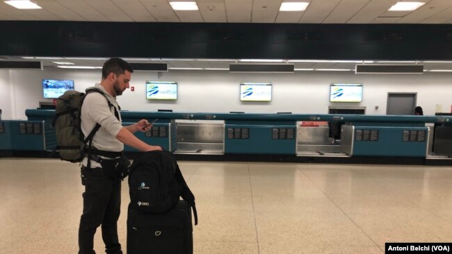 Un pasajero espera en la terminal de salidas del Aeropuerto Internacional de Miami tras conocer el anuncio de Donald Trump de cancelar todos los vuelos desde y hacia Europa debido al coronavirus.