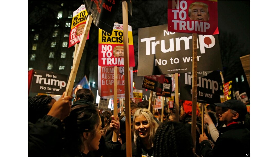 Demonstrators hold banners as they take part in a protest against U.S President Donald Trump's controversial travel ban on refugees and people from seven mainly-Muslim countries, outside Downing Street in London, Jan. 30, 2017.