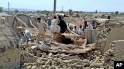 FILE — Pakistani villagers look for belongings amid the rubble of their destroyed homes following an earthquake in the remote district of Awaran, Baluchistan province, Pakistan, Sept. 25, 2013.