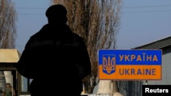 A Ukrainian border guard stands at a Russian-Ukrainian border crossing near the village of Uspenka, in eastern Ukraine, March 25, 2014.