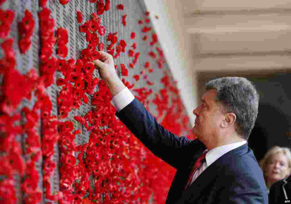 Ukraine&#39;s President Petro Poroshenko places a poppy in the World War I Honor Roll during a visit to the Australian War Memorial in Canberra. Poroshenko is on a two-day visit to Australia with talks on the downing of MH17 over Ukraine with the loss of 38 Australian citizens and residents expected to be high on the agenda.