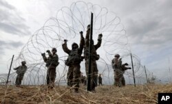 텍사스 도나에 주둔해 있는 국경 수비대를 지원하기 위해 배치된 미 육군들이 지난 4일 군 캠프 주위로 가시 철조망을 설치하고 있다.