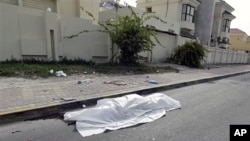 The body of a person killed during clashes between demonstrators and police lies in the street in Manama, on Feb 17 2011