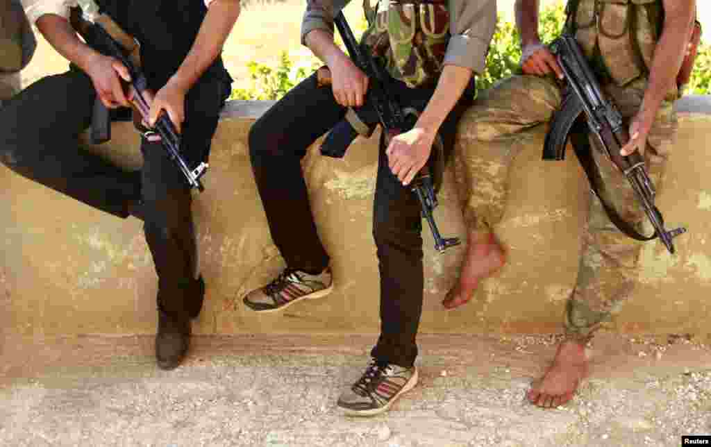 Free Syrian Army members rest with their weapons on a lookout point beside the Shi&#39;ite villages of Nubbul and Al-Zahraa in the Aleppo countryside, June 30, 2013.