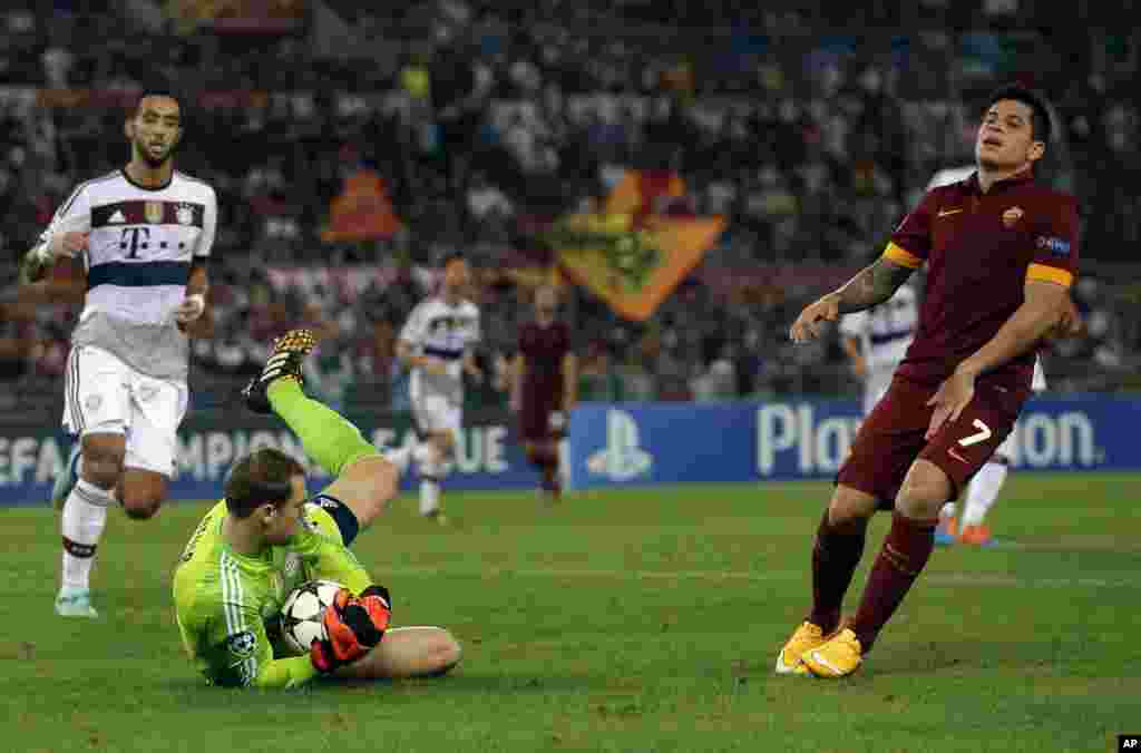 Le gardien de but du Bayern Manuel Neuer, à gauche, sauve lun boulet que Juan Manuel Iturbe Arevalos de Roma tiré pendant le match de football Ligue des Champions, Groupe E, entre Roma et le Bayern Munich au stade olympique, à Rome, le mardi 21 octobre 2014.