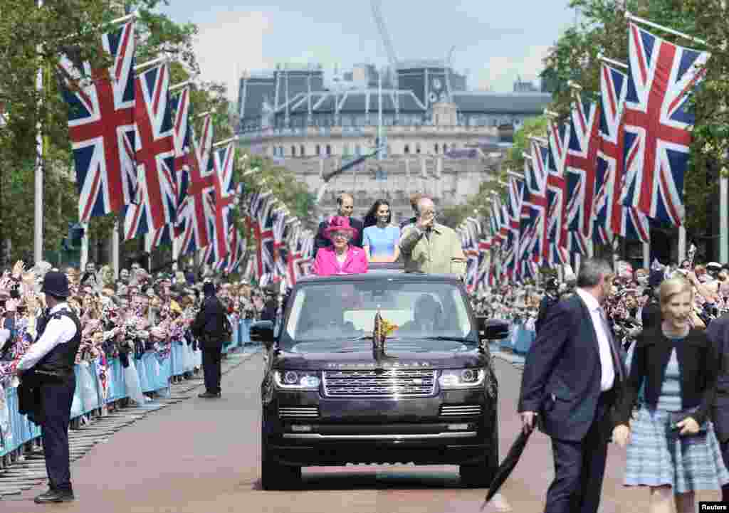 Britain&#39;s Queen Elizabeth and Prince Philip, and Princes William, Harry and Kate Duchess of Cambridge behind travel down the Mall waving guests during the Patron&#39;s Lunch, an event to mark her 90th birthday in London.