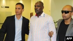 Nghi can chính trong cuộc diệt chủng Rwanda Ladislas Ntaganzwa (giữa) được hộ tống bởi an ninh đến sân bay Kigali ngày 20 tháng 3 năm 2016.