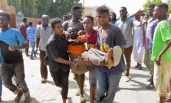 Sudanese carry a man injured during clashes as part of protests against a military coup that overthrew the transition to civilian rule, on October 25, 2021, in the capital Khartoum.