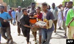 Sudanese carry a man injured during clashes as part of protests against a military coup that overthrew the transition to civilian rule, on October 25, 2021, in the capital Khartoum.