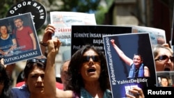 Demonstrators hold pictures of Ahmet Nesin, Sebnem Korur Fincanci and Erol Onderoglu during a protest against arrest of the three prominent campaigners for press freedom, in front of the pro-Kurdish Ozgur Gundem newspaper in Istanbul, Turkey, June 21, 2016.