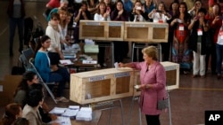 Mantan Presiden Chili Michelle Bachelet memasukkan surat suaranya ke kotak suara di salah satu TPS di Santiago, Chili (17/11)