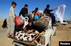 Iraqis fleeing the conflict in Kokjali are seen on the road east of Mosul, Iraq Nov. 3, 2016.