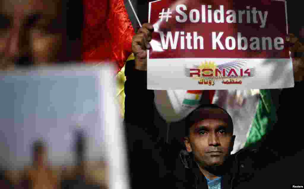 Kurdish men, living in Bulgaria, hold posters during a protest in solidarity with the Syrian Kurds in front of the European Parliament and European Commission offices in Sofia.