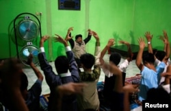 Recovering drug addicts and staff at a traditional rehabilitation center participate in physical activity during a prayer session led by Ustad Ahmad Ischsan Maulana in Purbalingga, Central Java, Indonesia, July 27, 2016. The center claims to have treated hundreds of addicts with a routine of herbal teas, baths, prayer and counseling.