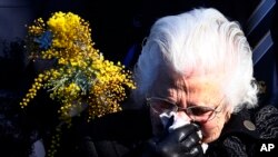 FILE - A relative of the Australian victims of Malaysia Airlines Flight MH17 reacts during a service for the unveiling of a memorial outside Parliament House in Canberra, Australia, July 17, 2015.