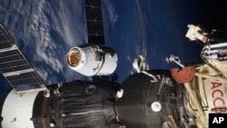 In this photo taken by Russian astronaut Sergey Ryazanskiy, the SpaceX Dragon capsule arrives at the International Space Station, Aug. 16, 2017. The capsule pulled up Wednesday following a two-day flight from Cape Canaveral, Florida.